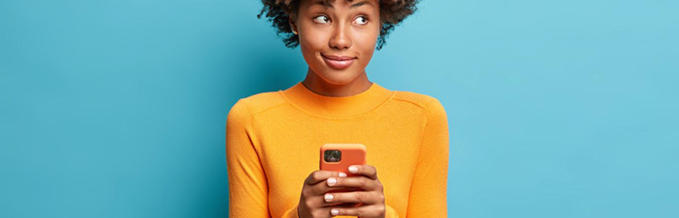 teen holding phone looking pensive