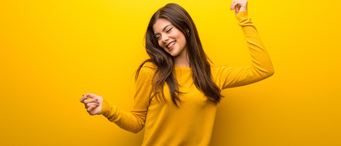 teen girl dancing, yellow background