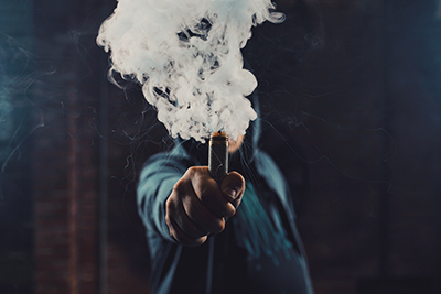 man holding smoking vape pen